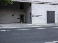 a building has a closed door and sign on the side of it with traffic cones next to it
