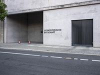 a building has a closed door and sign on the side of it with traffic cones next to it