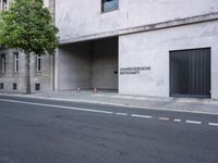 a building has a closed door and sign on the side of it with traffic cones next to it
