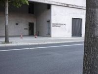 a building has a closed door and sign on the side of it with traffic cones next to it