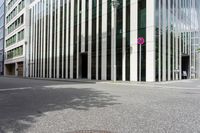 a paved city street lined with tall office buildings and a stop sign that is pointed down