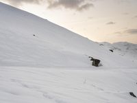 a snowboarder making his way down a snowy mountain slope with a sky background