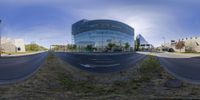 view looking through the two wide angle panoramic lenses on an empty street by a tall glass building