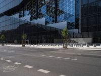 a parking lot sitting under a glass building on a street corner next to another building