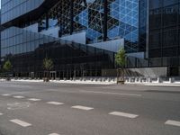 a parking lot sitting under a glass building on a street corner next to another building