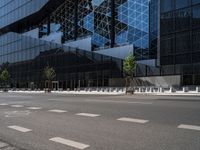 a parking lot sitting under a glass building on a street corner next to another building