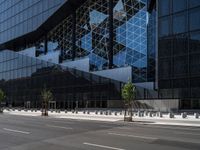 a parking lot sitting under a glass building on a street corner next to another building