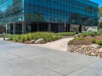 two grey blocks sitting next to a tall building on a sidewalk in front of grass