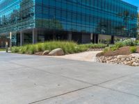 two grey blocks sitting next to a tall building on a sidewalk in front of grass