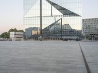 an empty plaza with several skyscrapers in the background and someone walking on the path