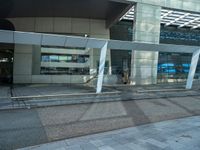 a street side building with an empty sidewalk outside of it and cars parked beside the building