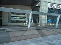 a street side building with an empty sidewalk outside of it and cars parked beside the building