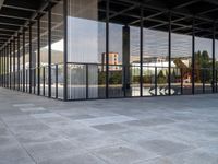 the large floor of a building with many windows in it's sides and an empty sidewalk on the side