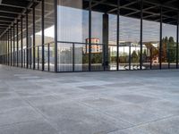 the large floor of a building with many windows in it's sides and an empty sidewalk on the side