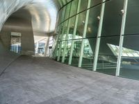 the hallway and walkways of a building with a curved glass wall in front of it