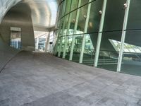 the hallway and walkways of a building with a curved glass wall in front of it