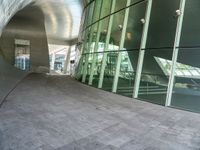 the hallway and walkways of a building with a curved glass wall in front of it