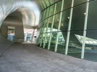 the hallway and walkways of a building with a curved glass wall in front of it