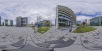 view looking at an outside area through a sphere shaped glass lens, with building buildings and a bench in the background