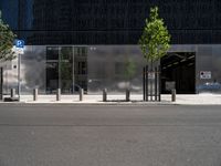 an empty street in front of a building and a parking meter next to it's entrance