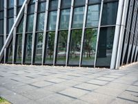 a yellow fire hydrant in front of a tall building with glass windows and gravel