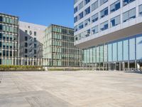 an empty square in front of some very tall buildings with windows to either side of it