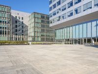 an empty square in front of some very tall buildings with windows to either side of it