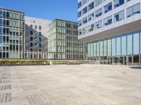 an empty square in front of some very tall buildings with windows to either side of it