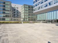 an empty square in front of some very tall buildings with windows to either side of it