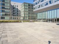 an empty square in front of some very tall buildings with windows to either side of it