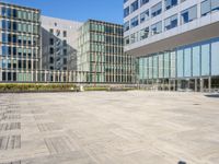 an empty square in front of some very tall buildings with windows to either side of it