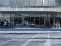 a man on his bike in front of a glass office building in the city streets