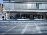 a man on his bike in front of a glass office building in the city streets