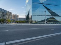 street view of modern building with triangular shapes reflecting the glass walls near by on a sunny day