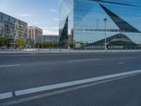 street view of modern building with triangular shapes reflecting the glass walls near by on a sunny day