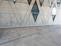 there is a small boy in front of an outdoor building that has geometric shapes and points