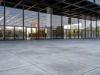 an empty public park has large glass windows on both sides and walls with seatings on each side