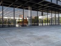 an empty public park has large glass windows on both sides and walls with seatings on each side