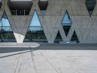 a skate board sits in front of some big building structures next to water and trees