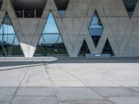 a skate board sits in front of some big building structures next to water and trees