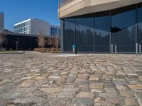 the large office building is located in the center of a cobblestone plaza of the city