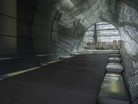 an escalator in a building with glass walls and metal roofing is viewed by several people