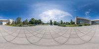 the 360 lens of this fish eye view shows the building and gardens of this public square