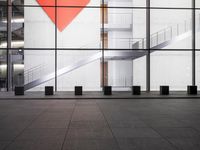 a glass and concrete building with steps leading up into the ceiling in front of the stairs