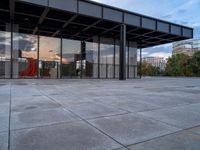 a building with metal structure and windows is empty in the sun set light from inside