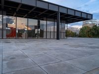 a building with metal structure and windows is empty in the sun set light from inside