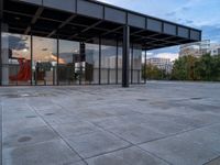 a building with metal structure and windows is empty in the sun set light from inside