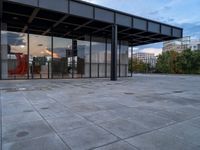 a building with metal structure and windows is empty in the sun set light from inside