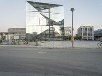 a city street with a reflection of a glass building on it with bicycles in the foreground