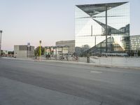 a city street with a reflection of a glass building on it with bicycles in the foreground